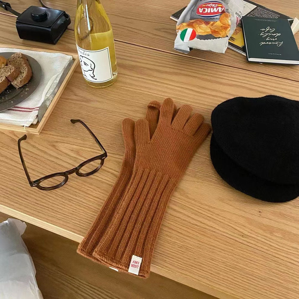 Gray winter knitted gloves with long sleeves displayed on mannequin hand