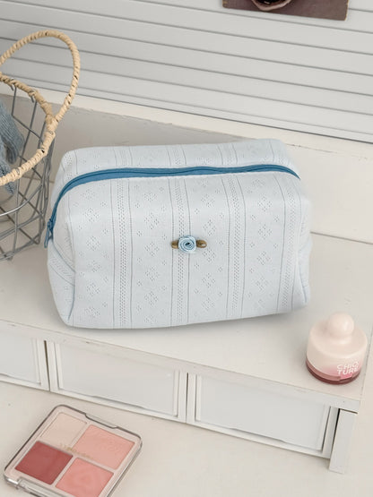 Cosbai cosmetic pouch placed on a white surface with lighting