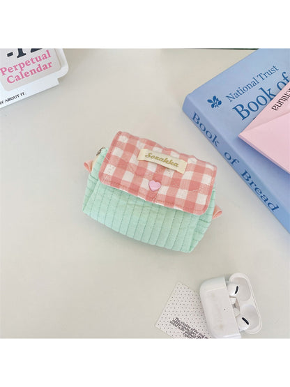 Cosbai cosmetic pouch placed next to makeup brushes and lipstick