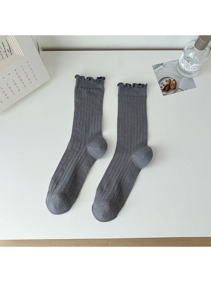 Rufia lace white mid-calf socks paired with a light outfit in natural light