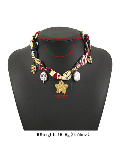 Side view of Neckit Botanical Charm fabric necklace highlighting fabric texture and charms