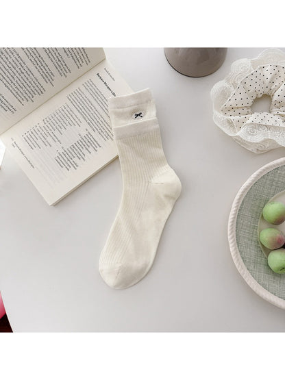 Side view of Rufia embroidered mesh mid-calf socks on model's legs