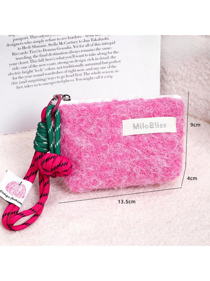 Cosbai fluffy mini pouch with wrist cord placed next to small accessories