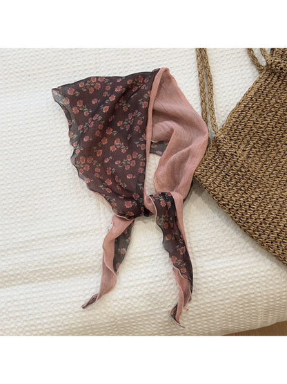 Model wearing lightweight botanical triangle scarf styled around the neck