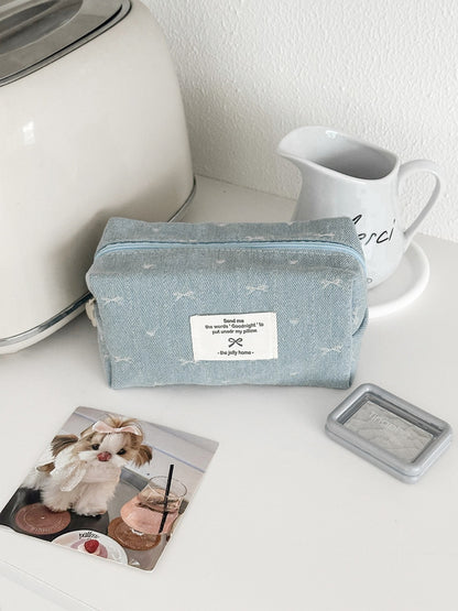 Cosbai soft washed denim pouch displayed with makeup brushes and cosmetics