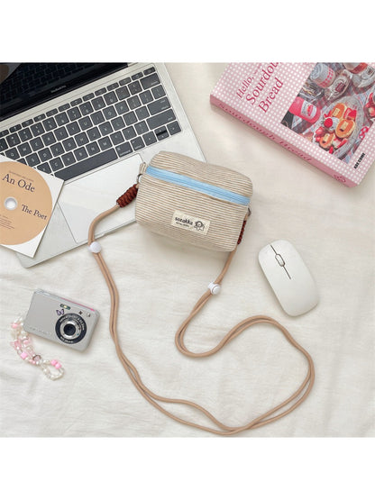 Cosbai striped mini crossbody pouch worn across the body on a model