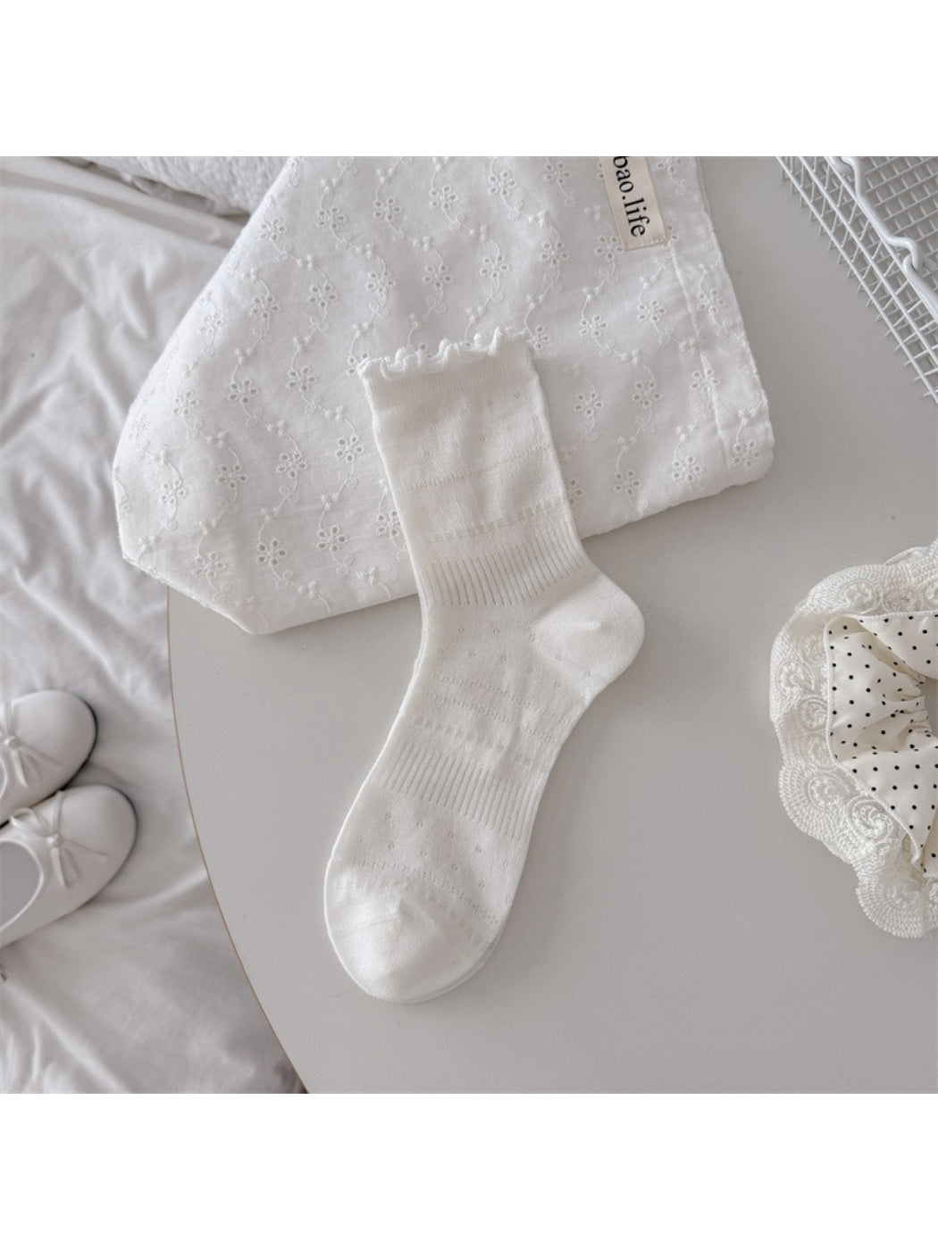 Side view of Rufia crew socks highlighting pointelle knit pattern and ruffle edge