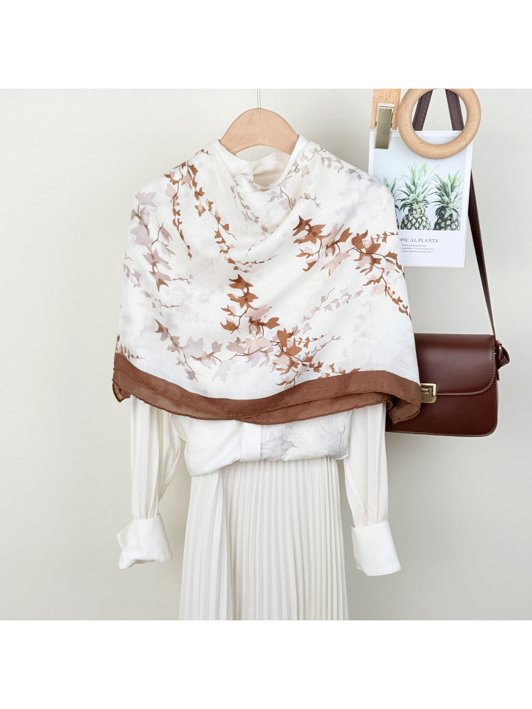 Scarvii leaf print wrap scarf displayed flat showing green and beige leaf pattern