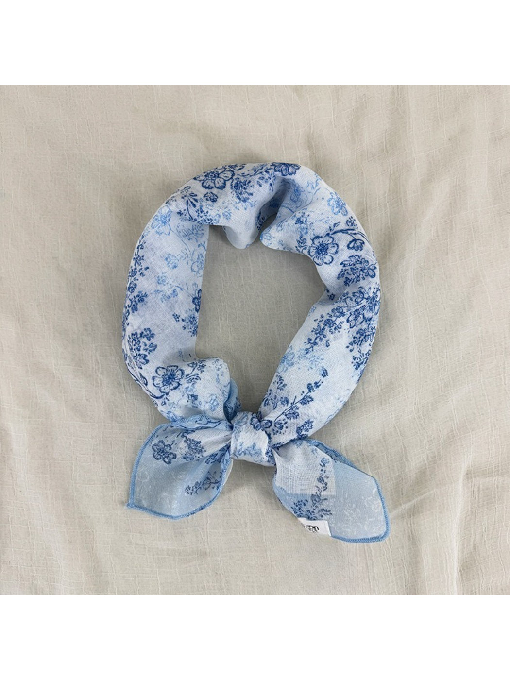 Close-up of delicate pink and white blossom print on lightweight scarf fabric