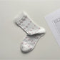 Rufia lace white mid-calf socks arranged to show full length and lace texture