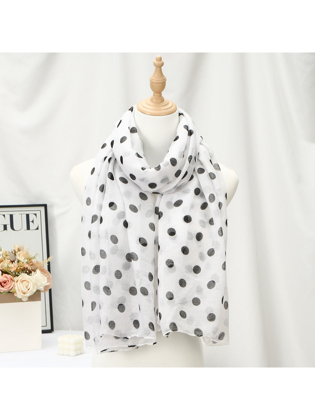 Model wearing soft polka dot wrap scarf styled around the neck
