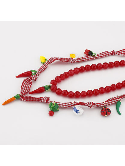 Model wearing the Neckit Playful Food Charm Necklace showcasing vibrant food charms