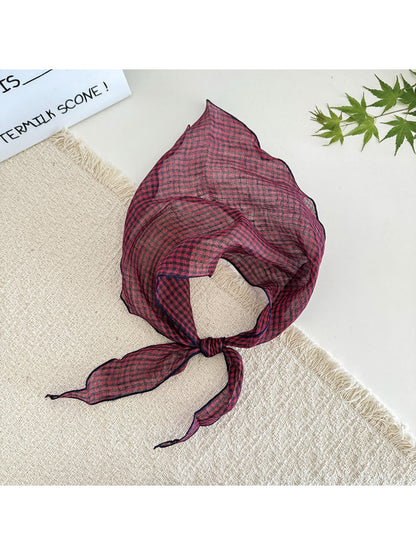 Classic check tie head scarf styled as a neck accessory on model
