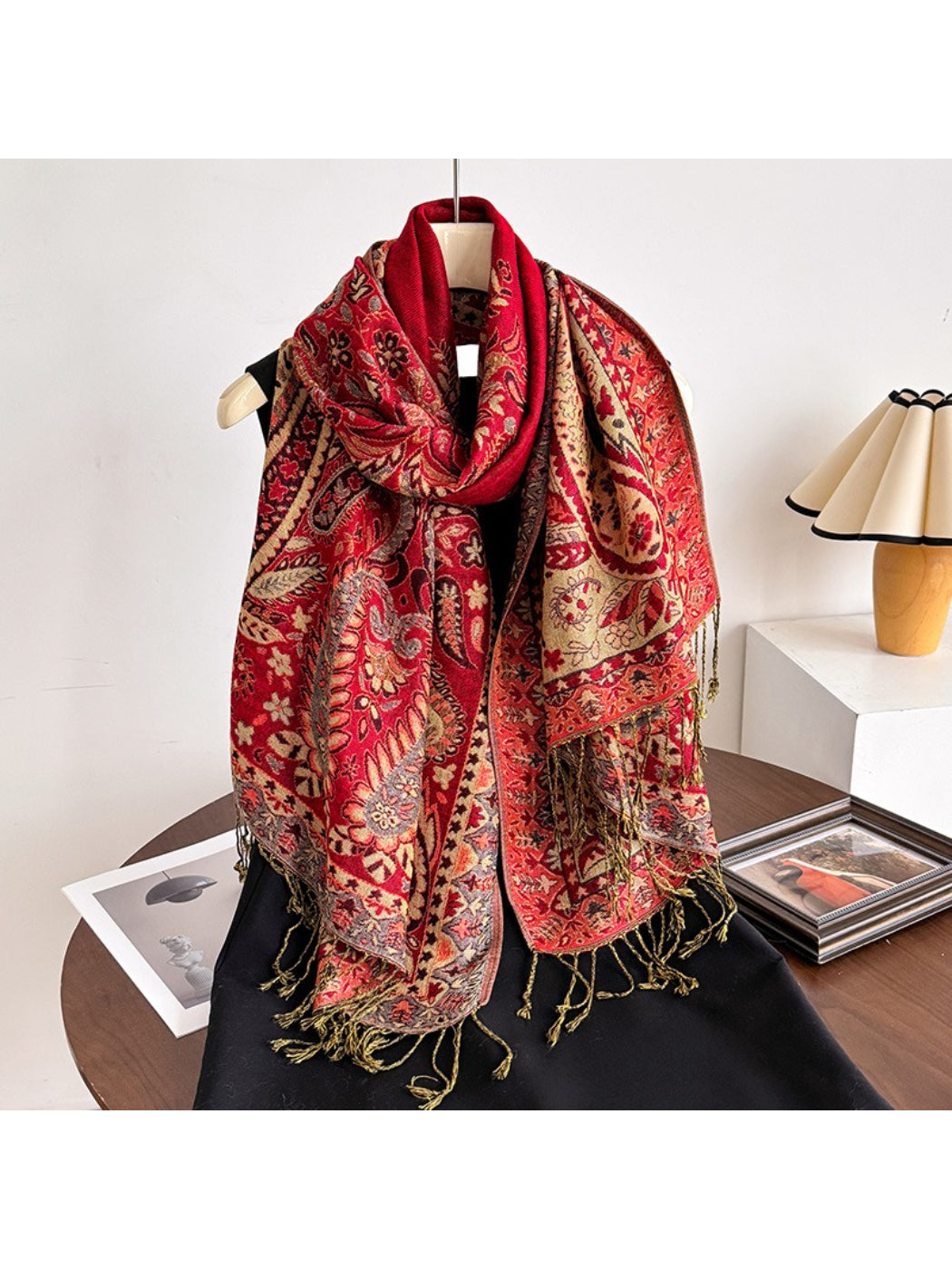 Close-up of scarf tassels hanging from the edges against a plain background