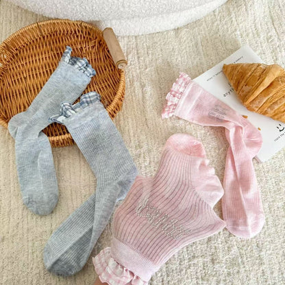 Pair of Rufia ruffle pastel mid-calf socks laid flat showing soft ruffle trim