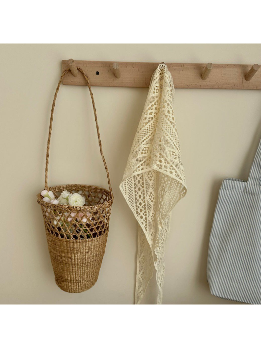 Close-up of intricate crochet pattern on cream boho triangle headscarf