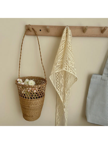 Close-up of intricate crochet pattern on cream boho triangle headscarf