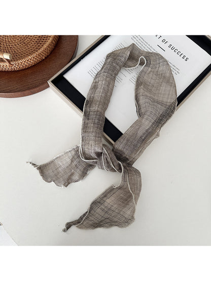 Soft textured skinny scarf styled with a coat on a mannequin