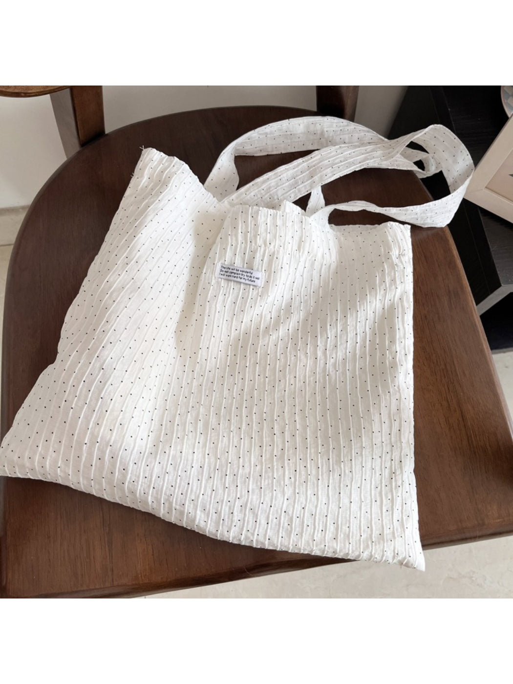 Side view of Cosbai white dotted crinkle tote bag showing handle detail