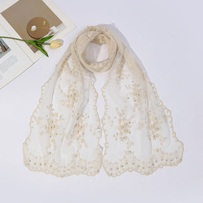 Model tying sheer botanical mesh scarf in a loose knot around the neck