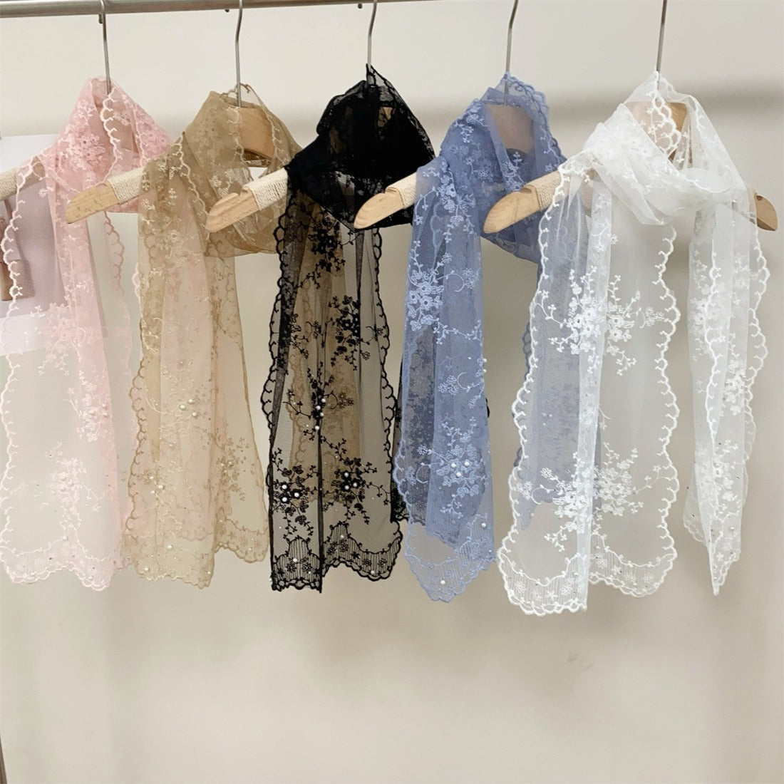 Sheer botanical mesh scarf draped over a white mannequin bust