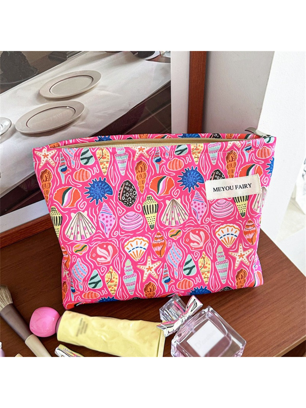 Close-up of Cosbai pink shell makeup pouch showing its curved silhouette and soft pink color