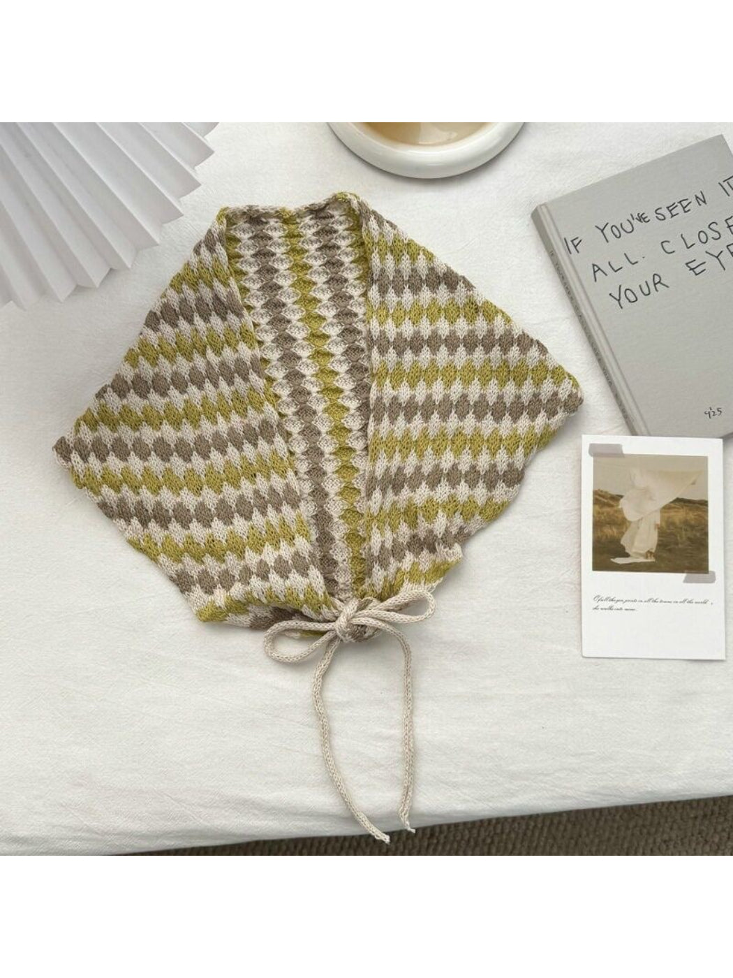 Side view of model with cream open knit diamond triangle scarf
