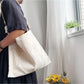 Ivory patterned hobo bag styled with casual outfit on a wooden surface