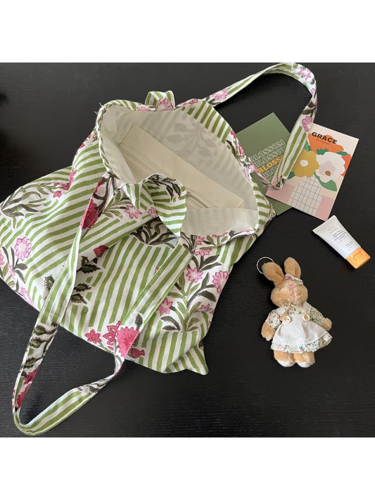 Cosbai floral stripe shoulder tote bag with attached white rabbit charm on a white background