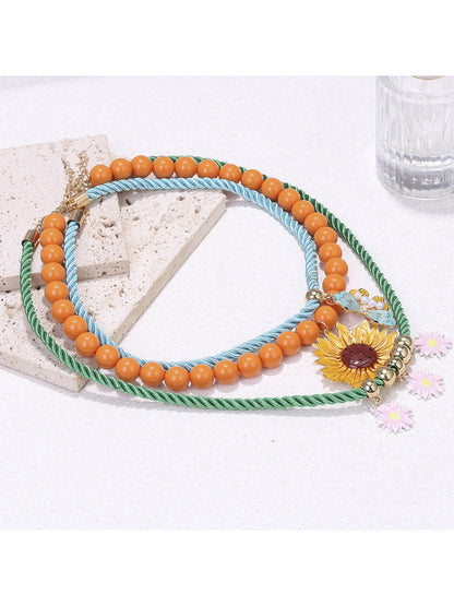 Neckit Sunflower Charm Rope Necklace displayed on a flat surface highlighting rope texture