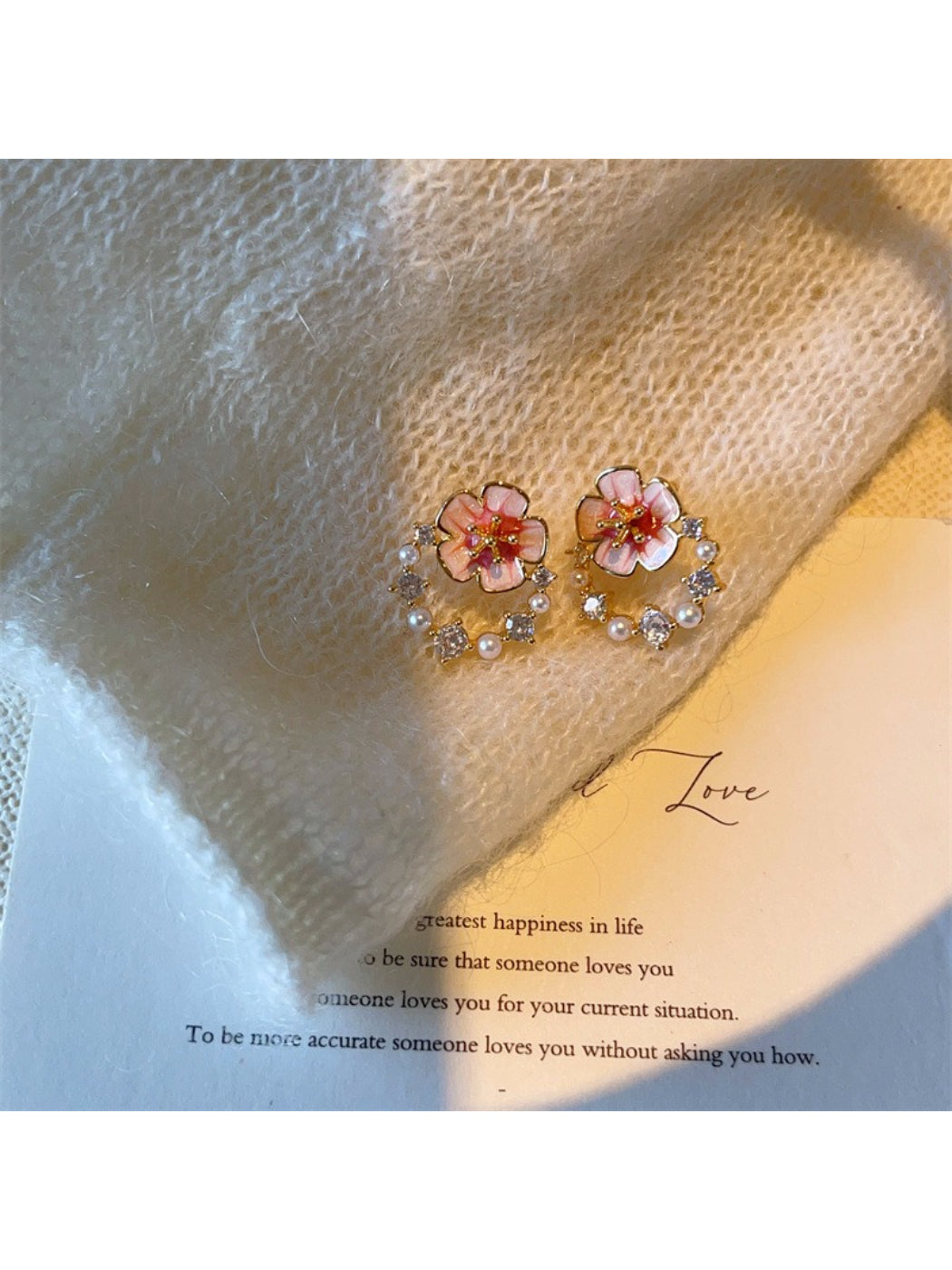 Close-up of Earwish pink flower accent earrings with gold-tone metal
