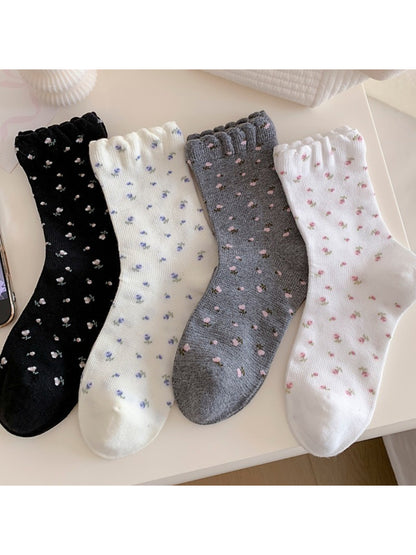 Stacked Rufia Tiny Blossom socks in multiple pastel shades with frill edges visible