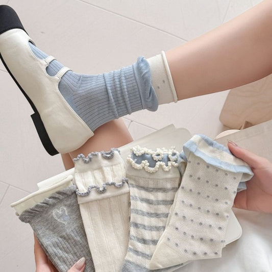 Pair of Rufia simple knit pattern crew socks in light gray on wooden surface