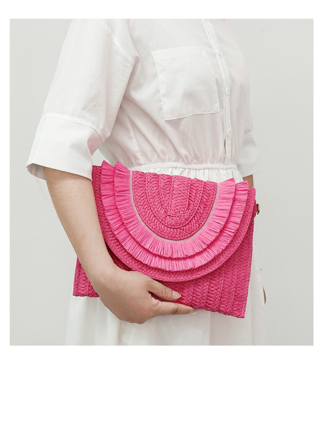 Cosbai woven tassel clutch bag resting on fabric surface