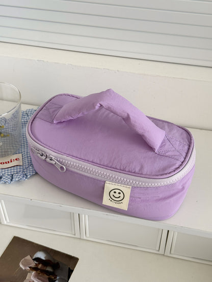 Cosbai Smiley Patch Cosmetic Bag angled to show shape and smiley patch