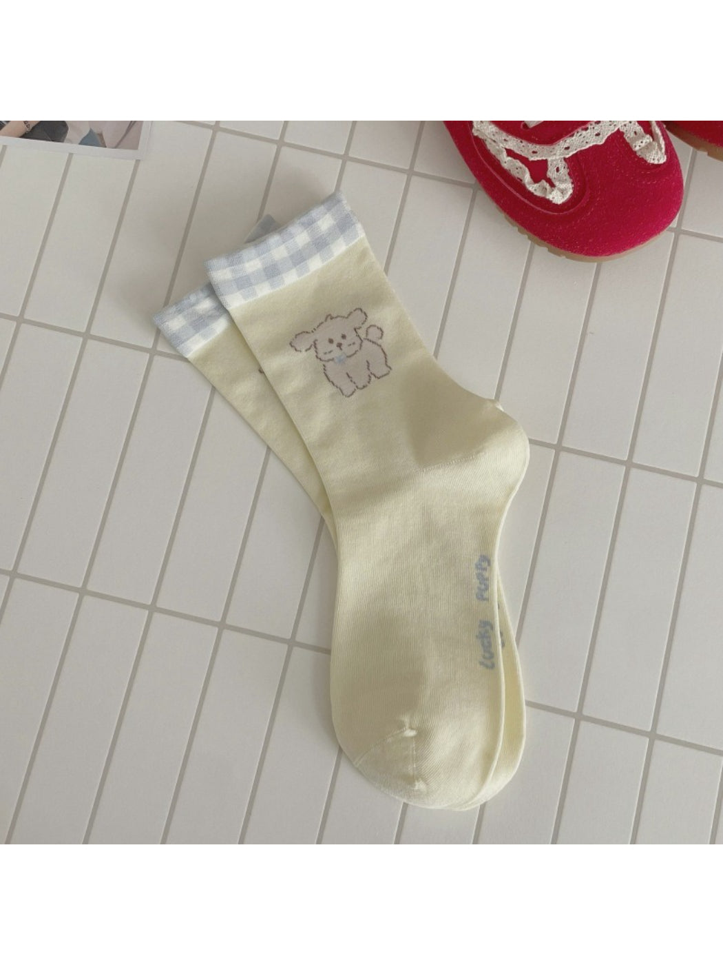 Rufia dog mid-calf socks worn on a dog model standing on a wooden floor