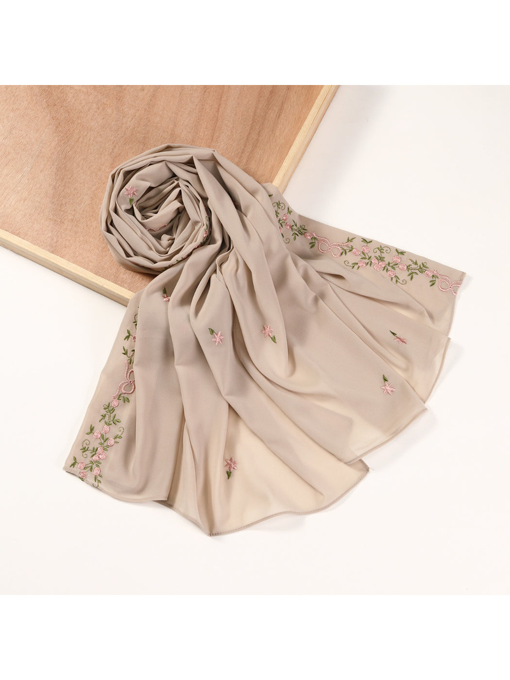 Model wearing soft botanical embroidered scarf around neck