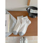 Stack of Rufia contrast toe ribbed ankle socks in white with black toe