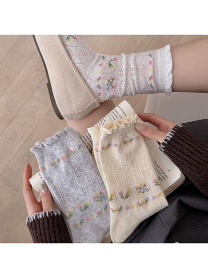 Pair of Rufia floral lace ankle socks displayed flat showing intricate lace pattern