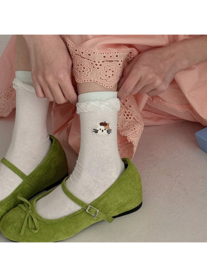 Pair of Rufia twisted cuff socks with black cat face detail on white background