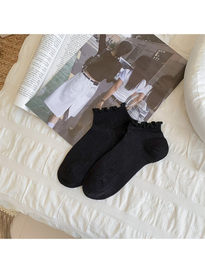 Rufia ankle socks worn on feet, highlighting bobble trim and ankle height