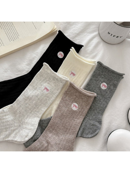 Pair of Rufia casual bow knit socks in light beige color displayed flat