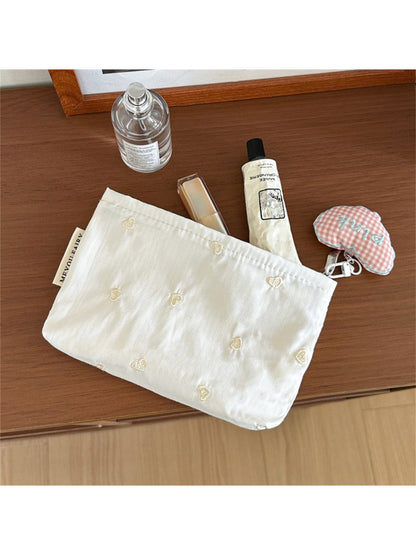 Cosbai cosmetic bag with heart pattern placed on vanity table