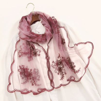 Close-up of Scarvii scarf embroidery featuring floral and scroll baroque elements