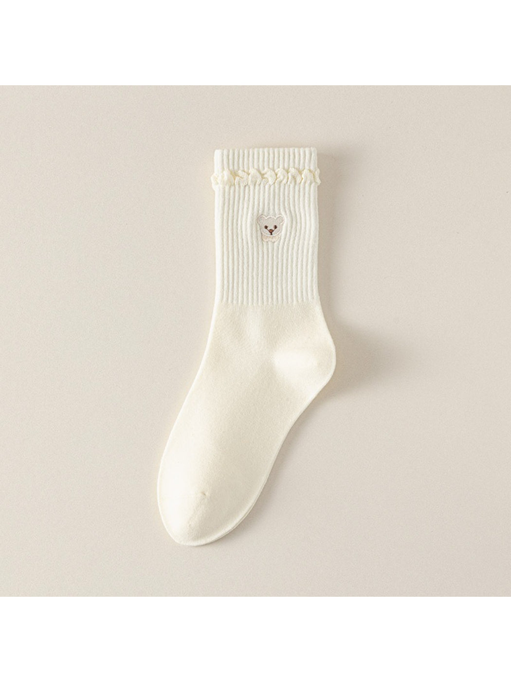 Side view of Rufia beige ribbed socks highlighting teddy cuff