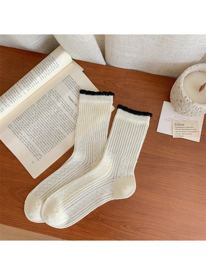 Flat lay of Rufia socks showing full length and subtle floral accents