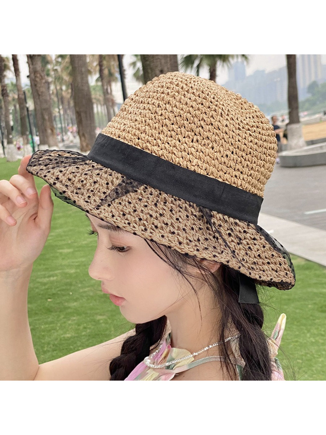 Top view of Haila hat highlighting black lace overlay on straw texture