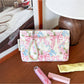 Cosbai cosmetic bag with bow detail and floral print on a plain background