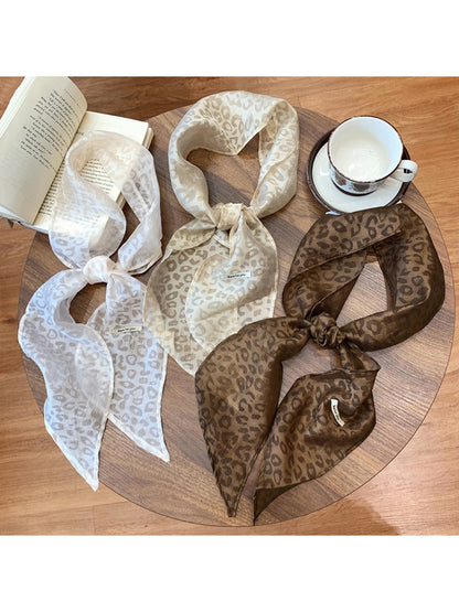 Sheer neck scarf with leopard print laid flat on white background