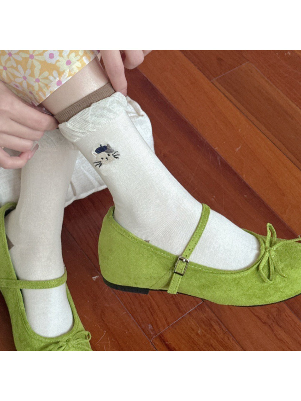 Close-up of twisted cuff and black cat embroidery on white everyday socks